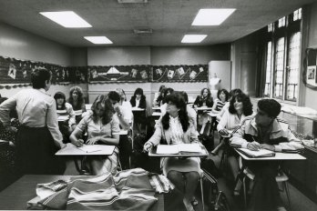 Several college students at desks in classroom