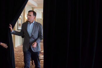 man opening up black curtain to walk through