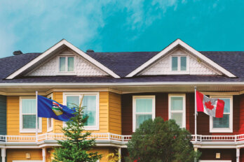 Image of the fronts of two houses. The leftmost is a yellow house flying the Alberta provincial flag, while the right is brown and flying the Canadian flag.