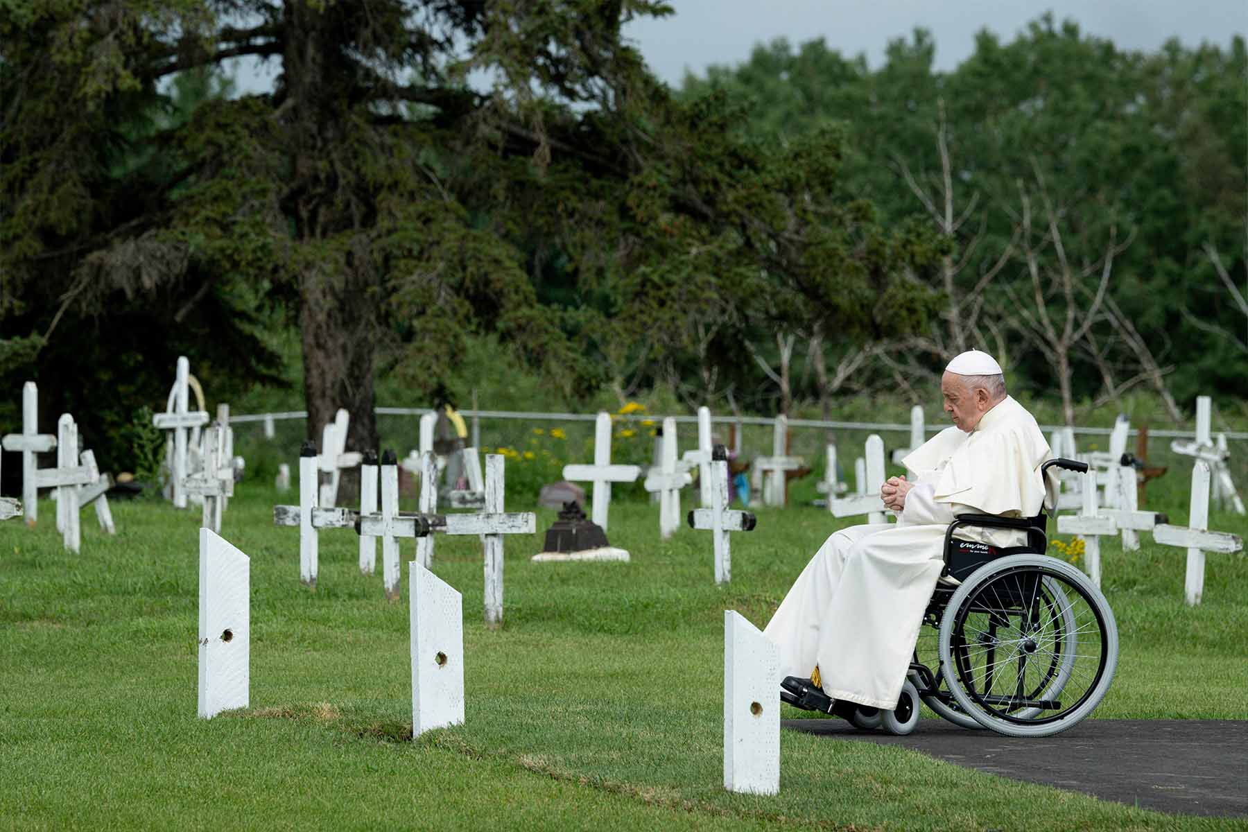 A photo of Pope Francis sitting in a wheelchair while praying at the Ermineskin Cree Nation Cemetery, in the community of Maskwacis, Alberta.