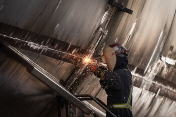 A worker wearing protective gear working in a factory