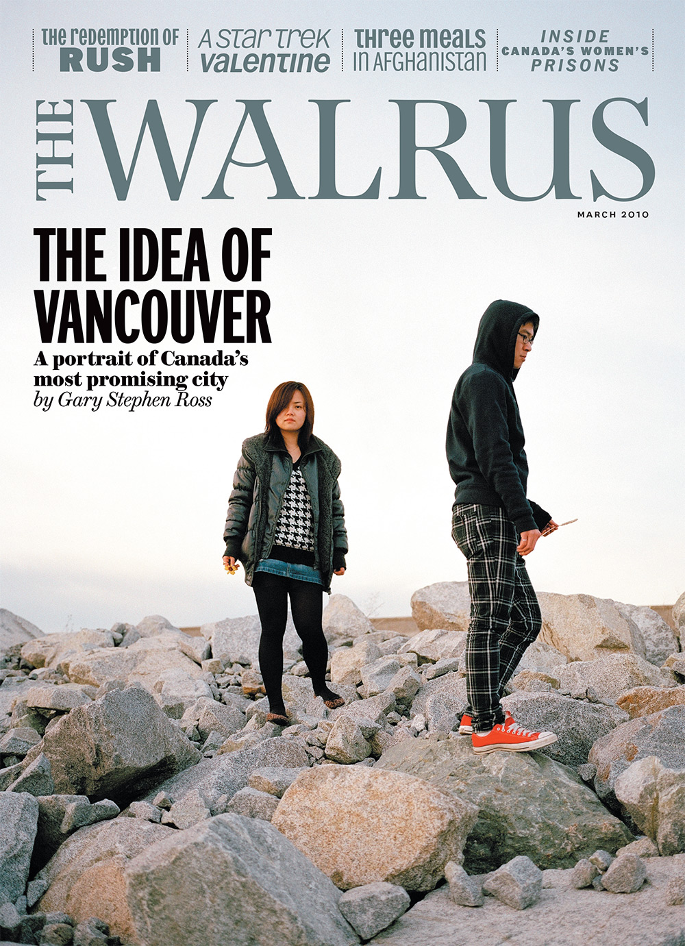 Cover of The Walrus magazine featuring a photo of two young people standing on a pile of large rocks. The Walrus wordmark is in blue at the top and the main headline reads 'The Idea of Vancouver.'