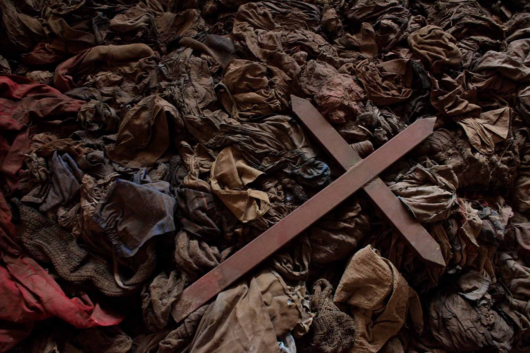 A wooden cross lies among clothes from some of the estimated 10,000 Tutsis killed in a two-day massacre at Nyamata church, now a memorial to the Rwandan genocide.