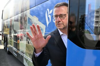 Bloc Québécois leader Yves-Francois Blanchet holds up a hand as he enters a bus