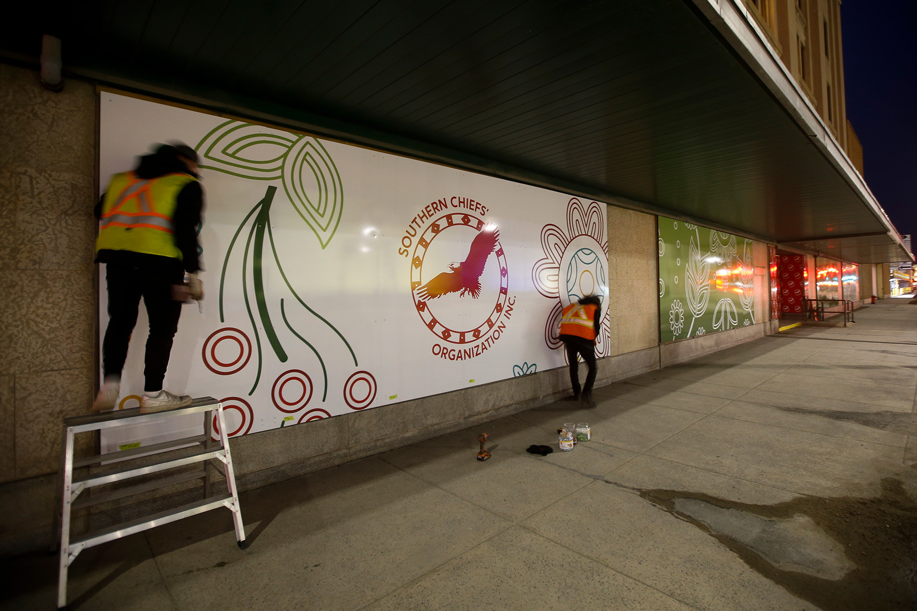 A Southern Chiefs’ Organization banner is installed on the Hudson’s Bay Company heritage building in Winnipeg, April 2022.