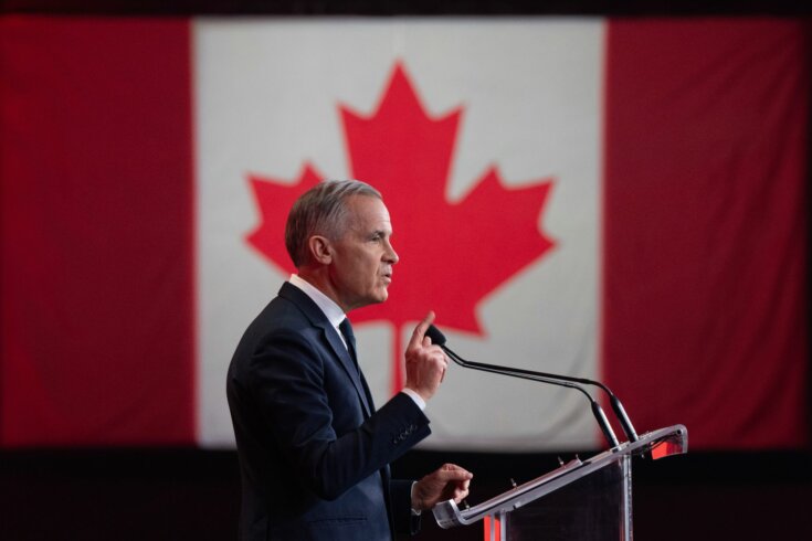 Photo of Prime Minister Mark Carney speaking at a podium with a Canadian flag in the background.
