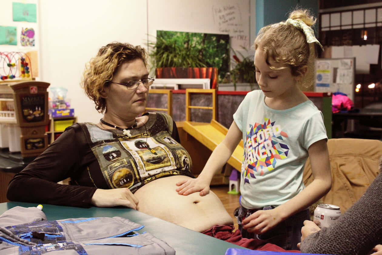 Andrea feels Sabrina’s pregnant belly at the Downtown Eastside Neighbourhood House