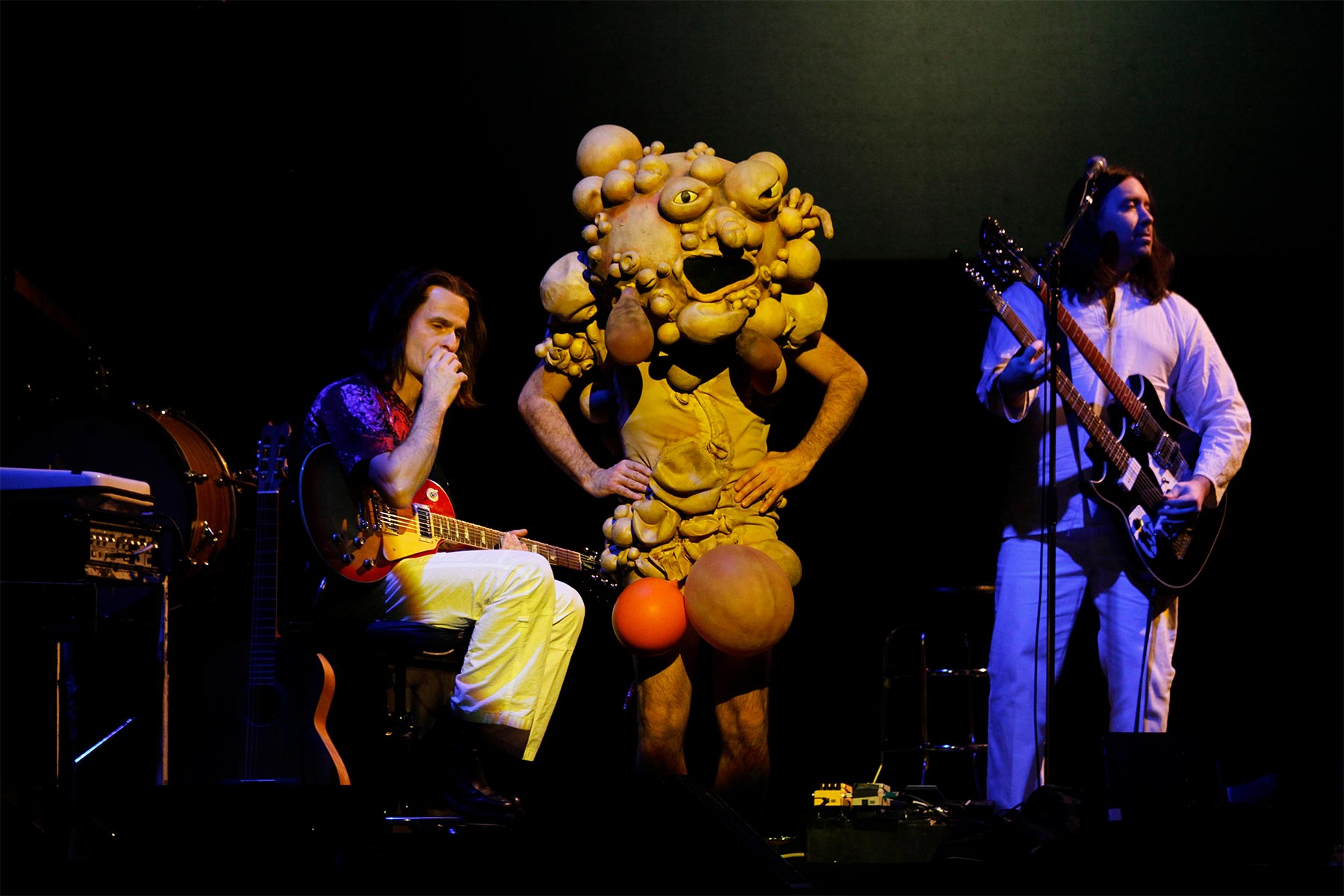A photo of Canadian tribute band the Music Box performing Genesis’s song “The Colony of Slippermen” as part of their recreation of their album The Lamb Lies Down on Broadway. Someone wears a costume of the deformed man described in the song.