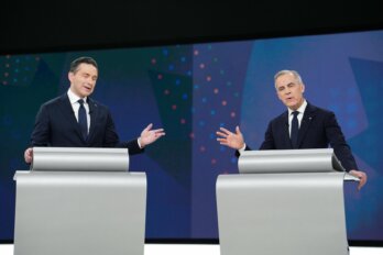 A photo of Pierre Poilievre and Mark Carney at the English election debate. Standing behind identical silver podiums, their hand gestures mirror each other