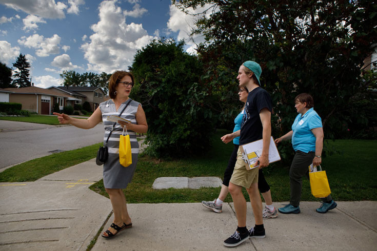 Jane Philpott walks with others down a neighbourhood street