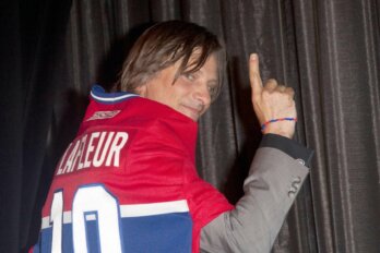 Photo of actor Viggo Mortensen with his back mostly turned to the camera. He is wearing a red and blue Montreal Canadiens jersey with the name "Lafleur" and the number 10 on the back.