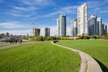 A photo of a pathway snaking through green grass with buildings in the background.