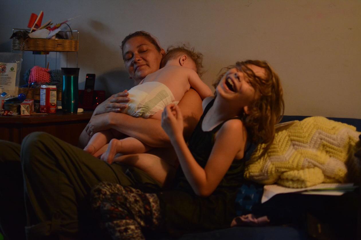 Andrea giggles as she tries to make her new sister, Loretta, laugh