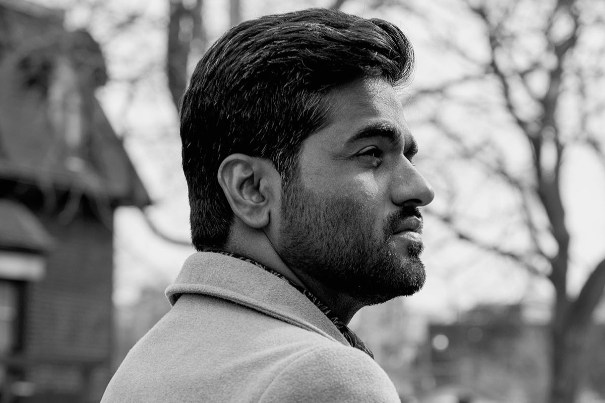 Lateef Johar, wearing a collared coat, is pictured in profile in a black-and-white photo taken on a Toronto street in winter.