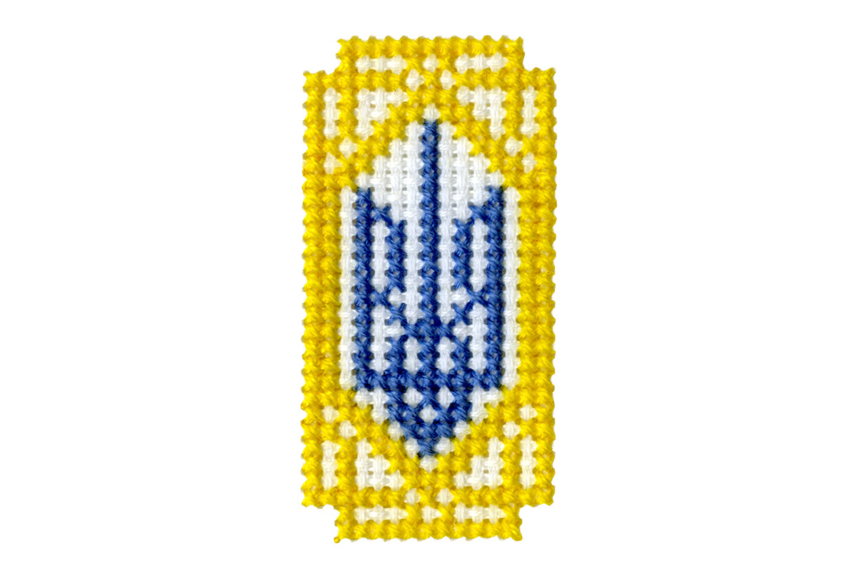 The Ukrainian coat of arms cross stitched in blue and yellow thread on aida cloth