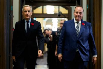 Photo of Prime Minister Mark Carney and politician Chris d'Entremont walking together down a hallway.