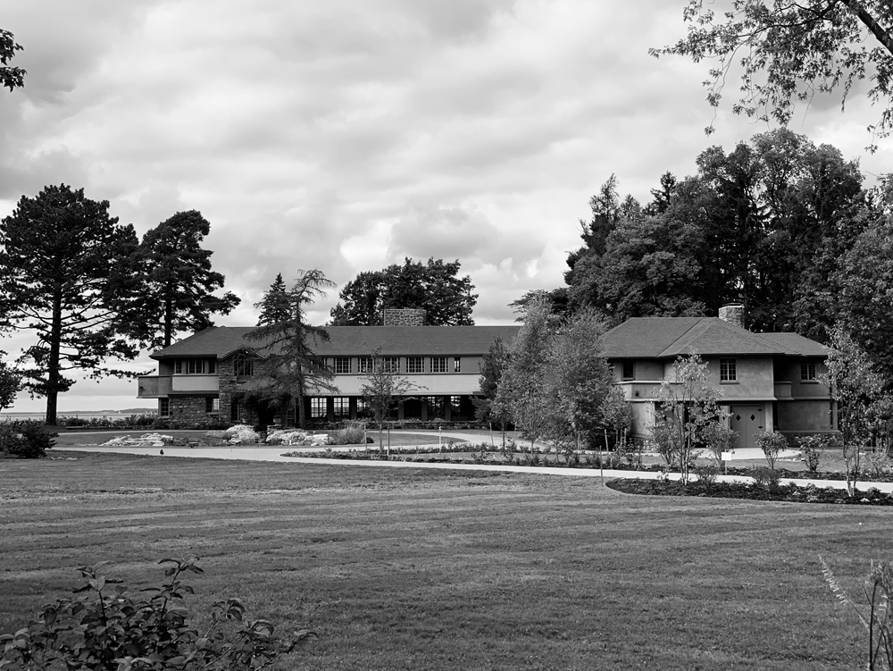 A black and white photo of a Frank Lloyd Wright home surrounded by trees.