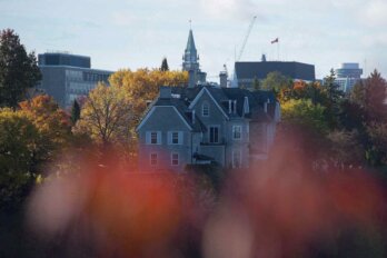 Photo of the prime minister's residence, 24 Sussex Drive, taken above out-of-focus autumnal leaves.