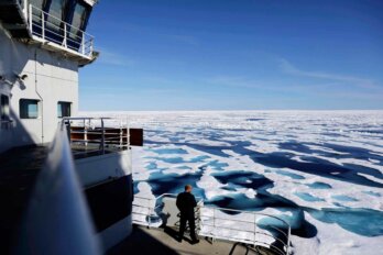 A Canadian Coast Guard official looks out from an icebreaker as it traverses the Northwest Passage through the Canadian Arctic Archipelago.