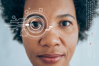 A close up of a Black woman's face with circles and circuit imager around her eye and data alongside her face, depicting facial recognition