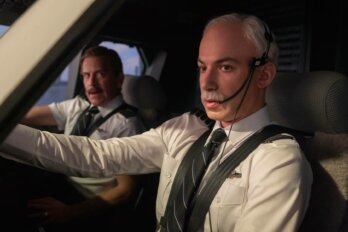 A film still from docu-series The Rehearsal. In frame, Nathan Fielder is in frame as a pilot with his co-pilot beside him in a plane's cockpit.