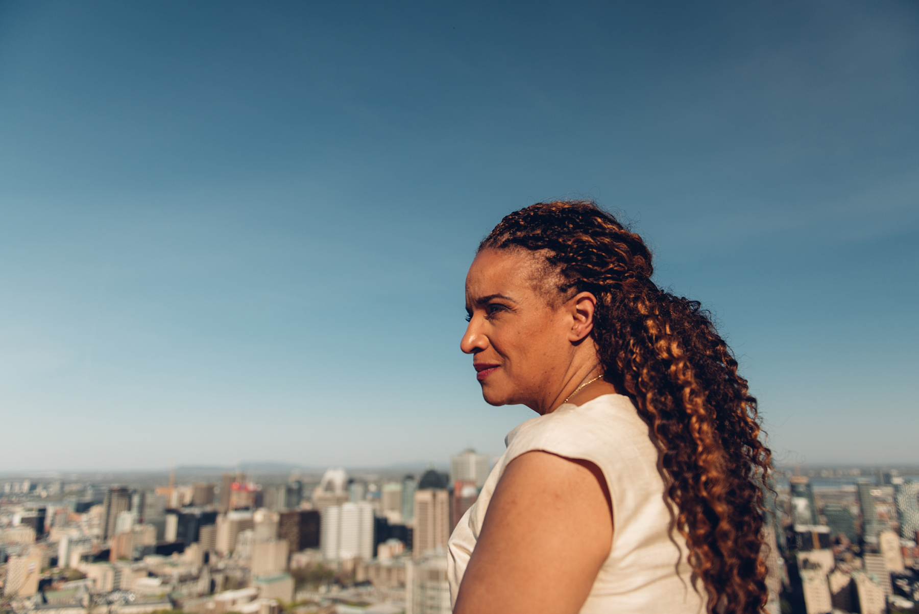 Photo of Tamara Thermitus looking out over the Montreal skyline on a clear day.