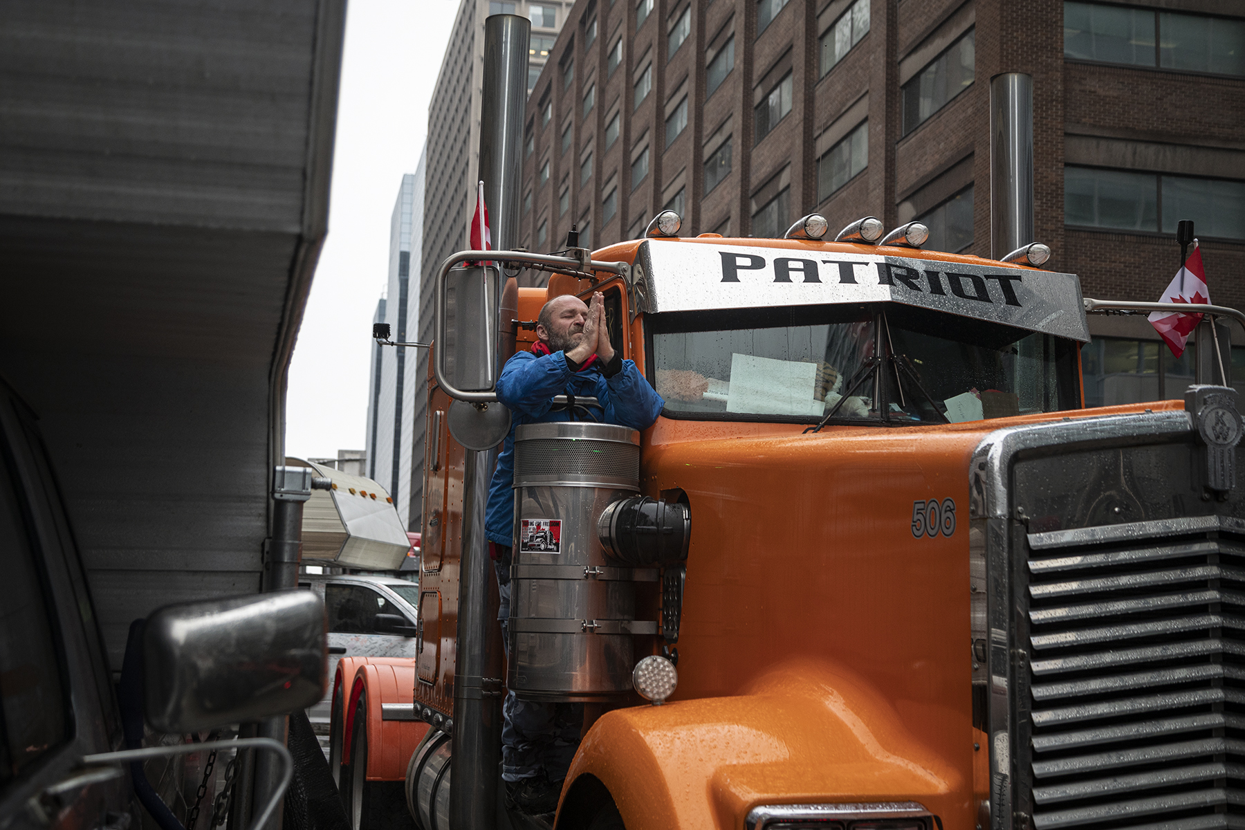 A man appears to pray while on a truck on the corner of Slater and Bank street in Downtown Ottawa.