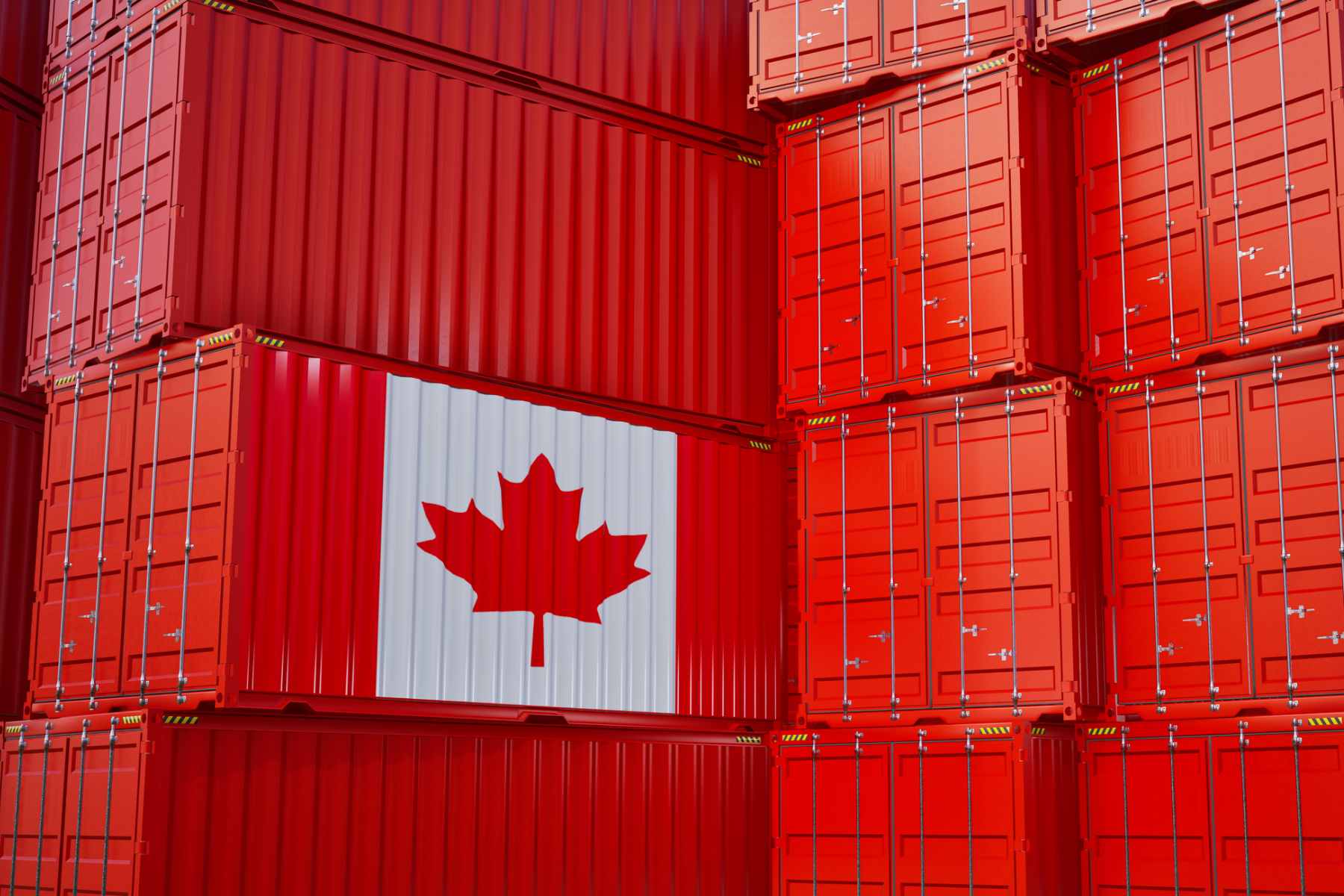 Image of stacks of red shipping containers with one depicting the Canadian flag design on the side.