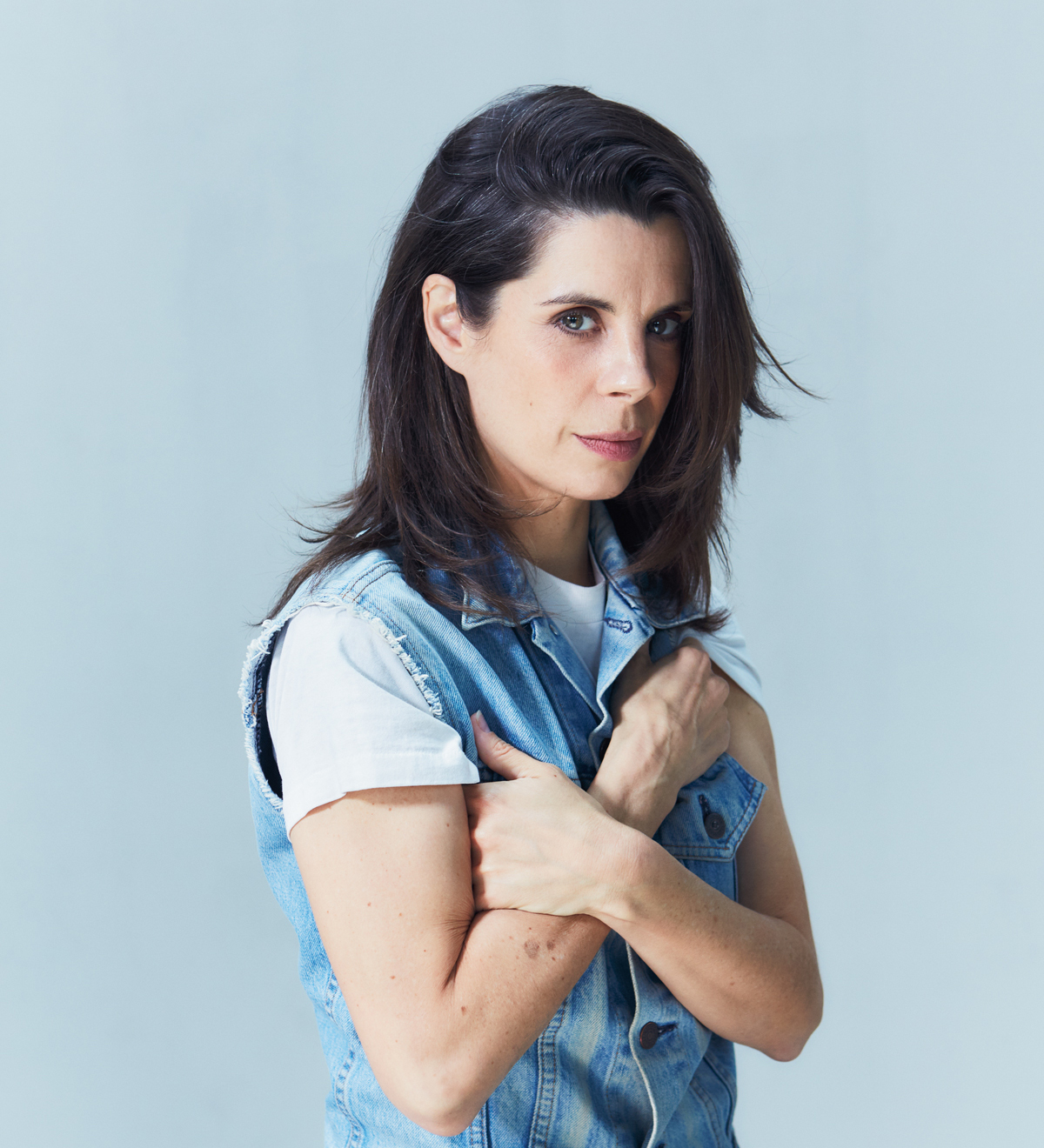 Portrait of comedian Meredith MacNeill, in a sparse room. 