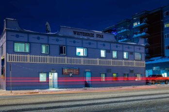 A dark winter night with a neon blur over the Whitehorse Star building