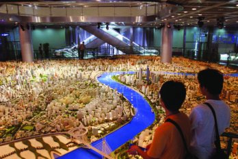 Two people look out at a room-sized model in the Shanghai Urban Planning Museum shows what central Shanghai will look like in 2020.