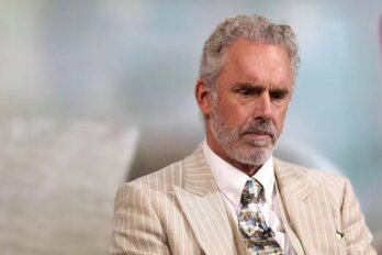 Photograph of Jordan Peterson in a beige striped suit.