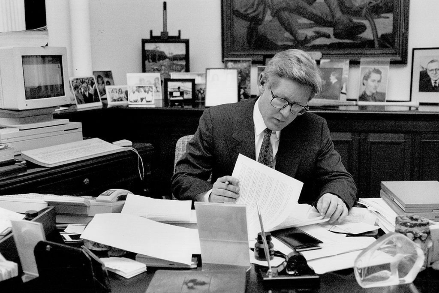 A black-and-white photo of former Ontario premier Bob Rae working at his desk