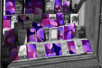 A photo illustration of a black-and-white book shop window. Half of the books feature covers with purple, abstract blobs