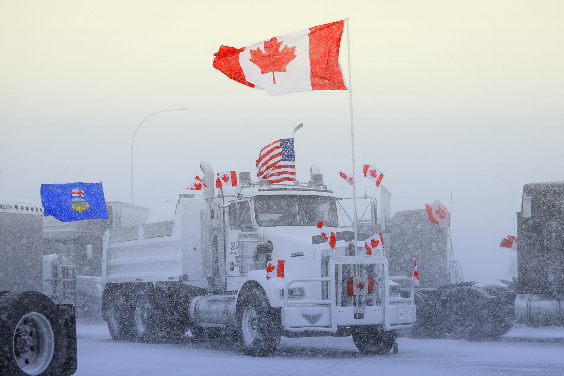 A photo of a truck covered in Canadian and American flags.