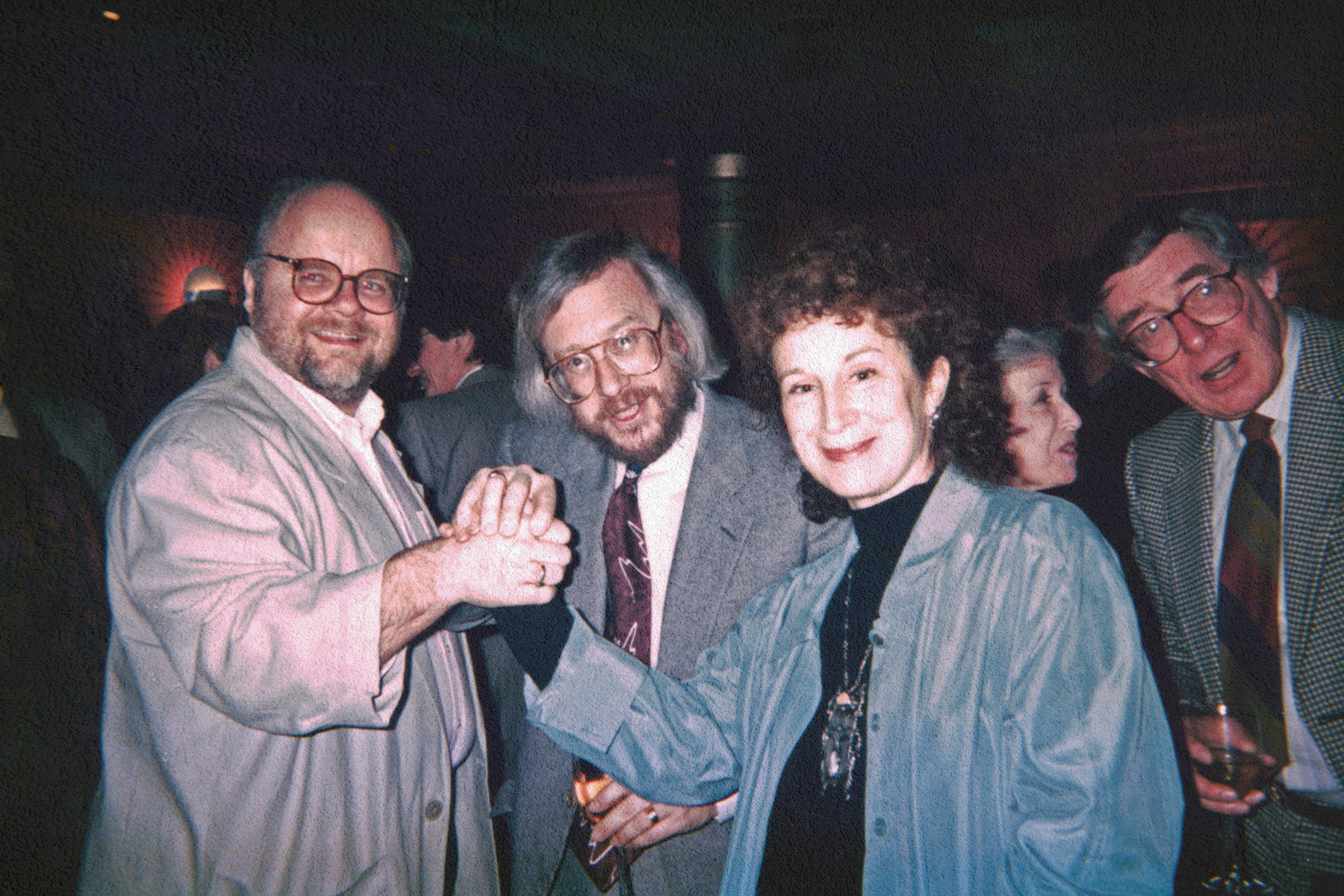 Photo of four people. Three are men in business suits, and one, the woman, is author Margaret Atwood.