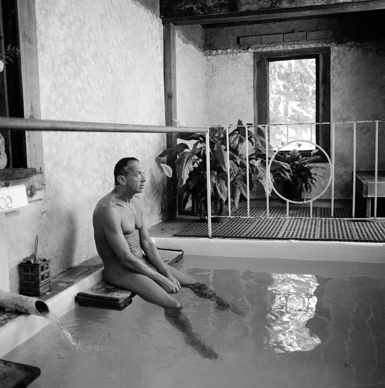 Man sitting on bench by mineral pool