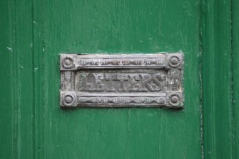 old mailbox on a green door
