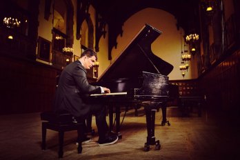 Colin Dutcher playing piano with room with high-vaulted ceilings
