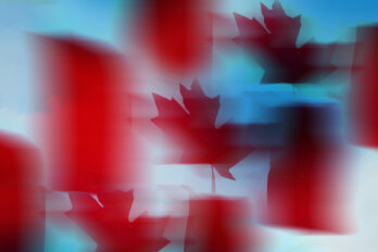 A photo illustration of a cycle of three Canadian flags, blurring in and out of focus