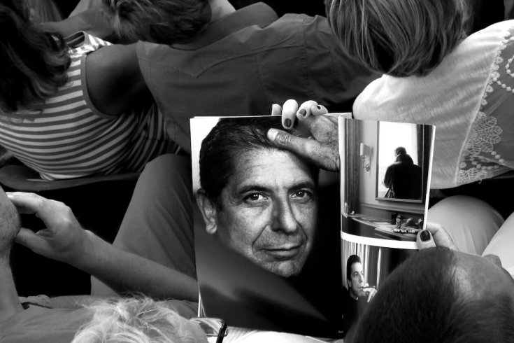Photograph of a Woman Looking at a Leonard Cohen Themed Magazine Spread