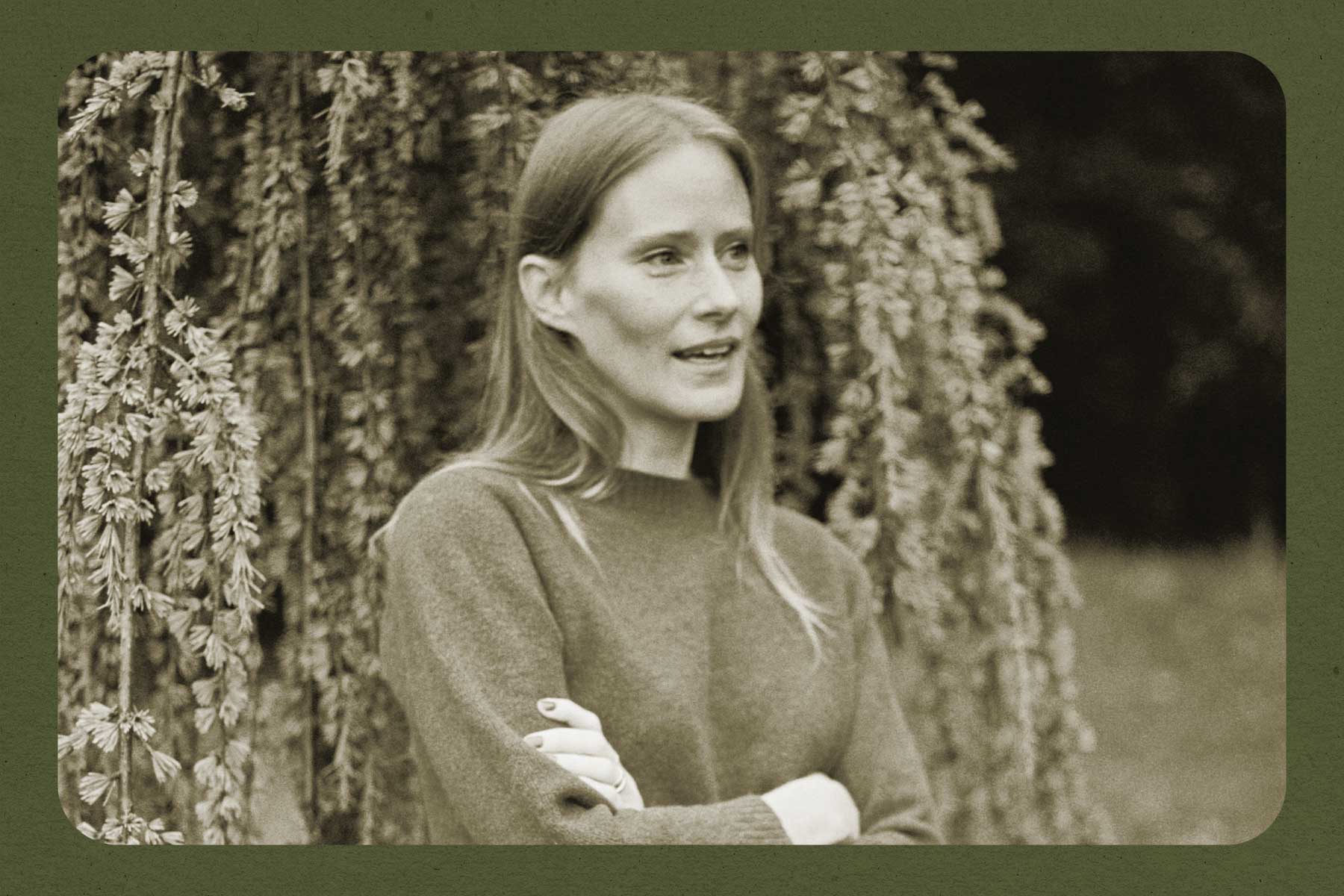 A black-and-white photo of author Sarah Bernstein standing in front of a tree with her arms crossed. There is a green border around the image.