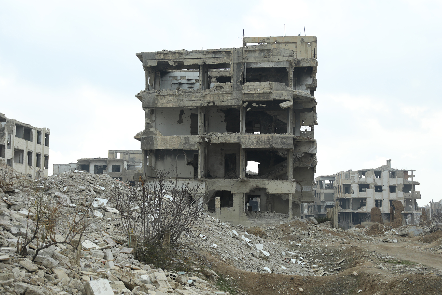 A file photo of the skeleton of a mid-rise building with debirs and rocks on the ground below