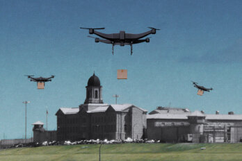 Image of three delivery drones flying above a grey prison building.