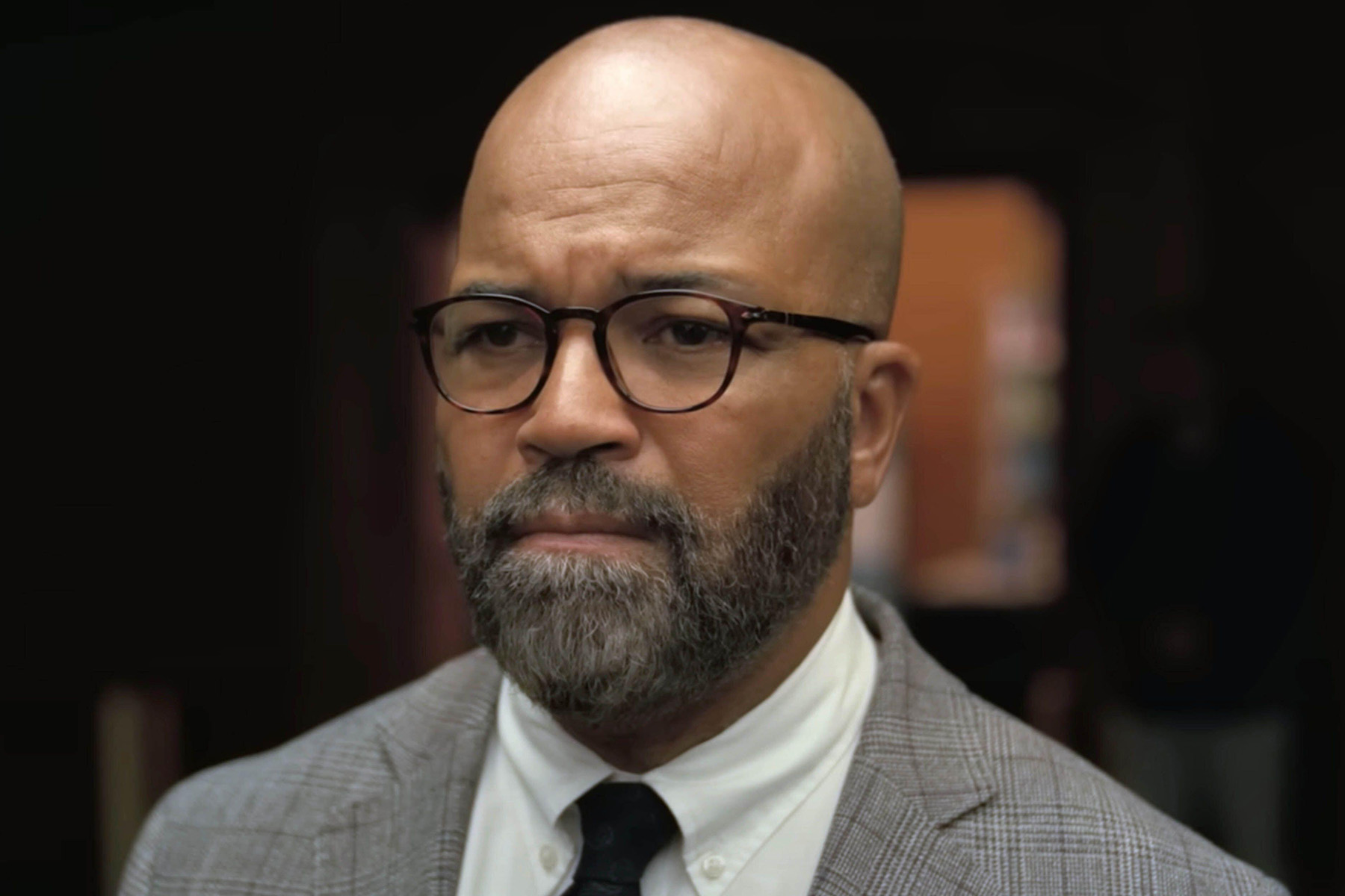 A close-up photo of Jeffrey Wright, wearing a grey suit, black tie, and worried expression, in the movie American Fiction.