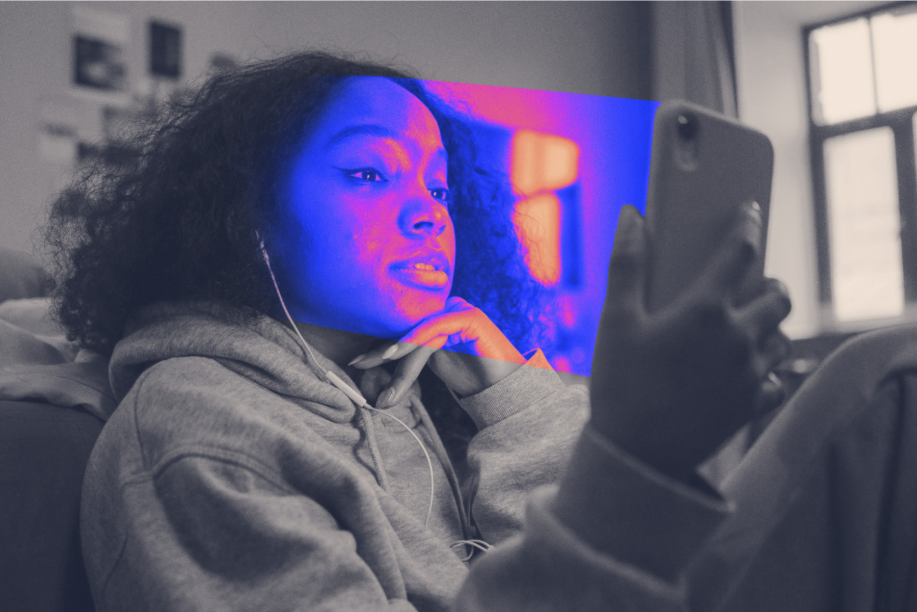 A teenage girl stares at her smartphone in a black-and-white photo; the phone casts a technicolour glow.