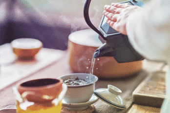 Someone pouring sparkling tea out of a kettle.