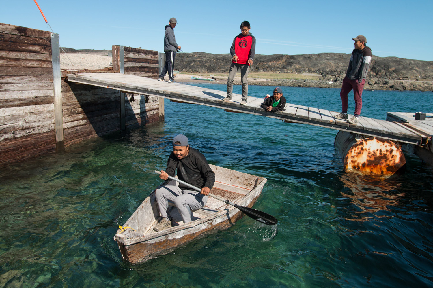 A child rows a boat in the water.