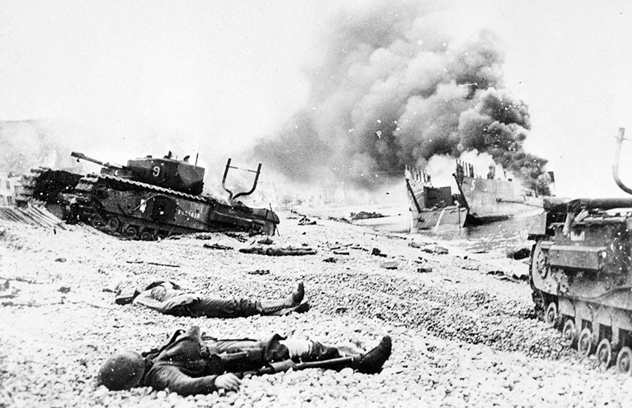 Canadian casualties lie among damaged landing craft and Churchill tanks