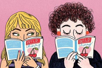 Two girls holding books in front of their faces